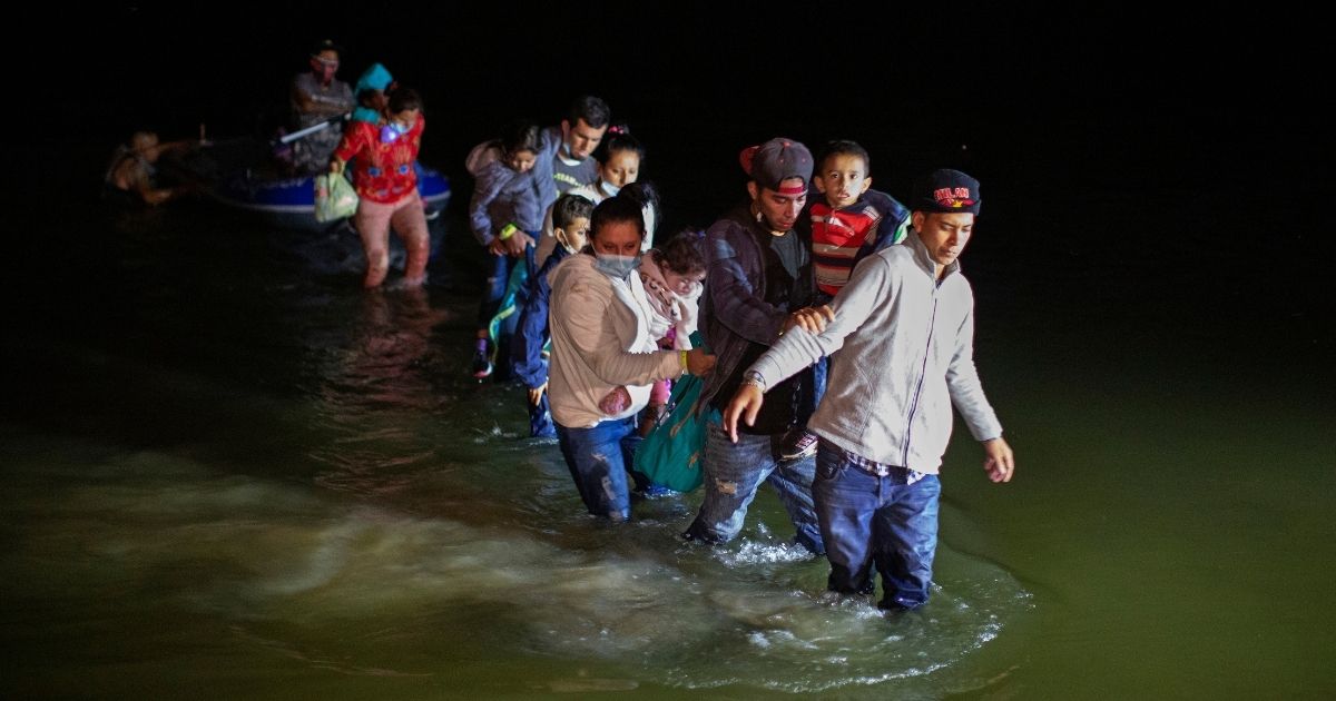 Illegal immigrants, mostly from Central American countries, wade through shallow waters in the Rio Grande after being delivered by smugglers on small inflatable rafts in Roma, Texas, on Wednesday.
