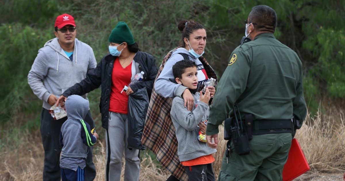 A group of migrants is processed by a U.S. Border Patrol agent after crossing the United States border illegally from Mexico on Monday in La Joya, Texas.