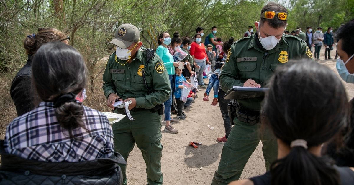 Border Patrol agents question a group of illegal immigrants who crossed the Rio Grande from Mexico into Hidalgo, Texas, on Thursday.