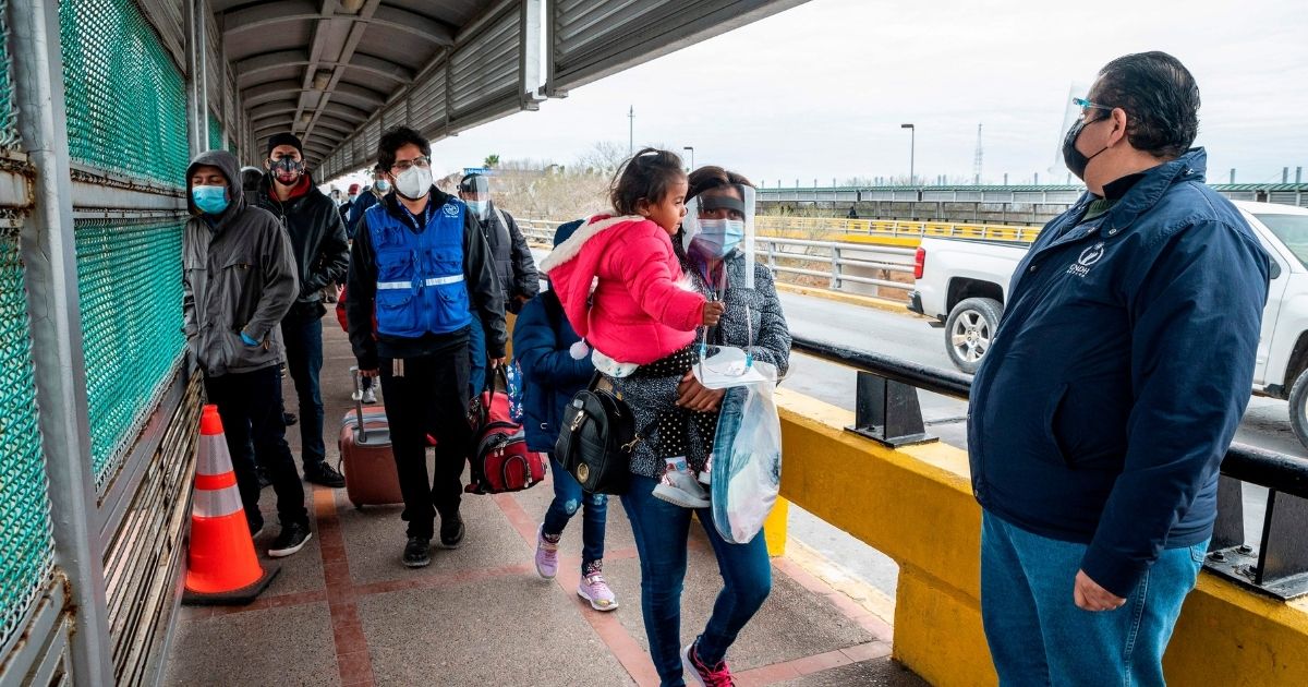 A migrant family approaches the U.S. border on Gateway International Bridge in Brownsville, Texas on March 2, 2021.