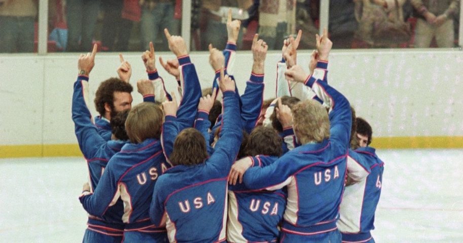 Members of the American Men's Olympic ice hockey team celebrate on the medal podium after receiving their gold medals in Lake Placid, New York, on Feb. 24, 1980.