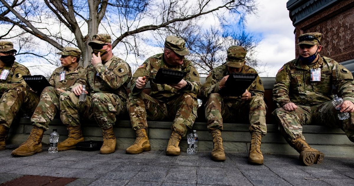 National Guard soldiers eat some chow before being issued their M4 rifles and live ammunition on the east front of the U.S. Capitol on Jan. 17, 2021, in Washington, D.C.
