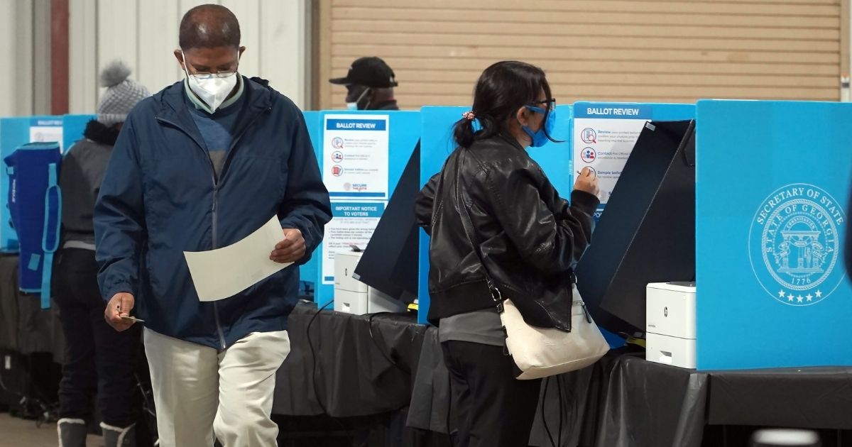 Georgia voters mark their ballots during the first day of early voting in the U.S. Senate runoffs at the Gwinnett County Fairgrounds on Dec. 14, 2020, in Atlanta.