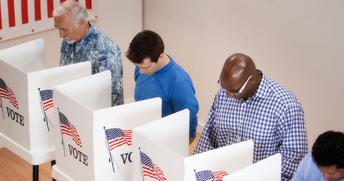 People vote in a polling place in the above stock image.