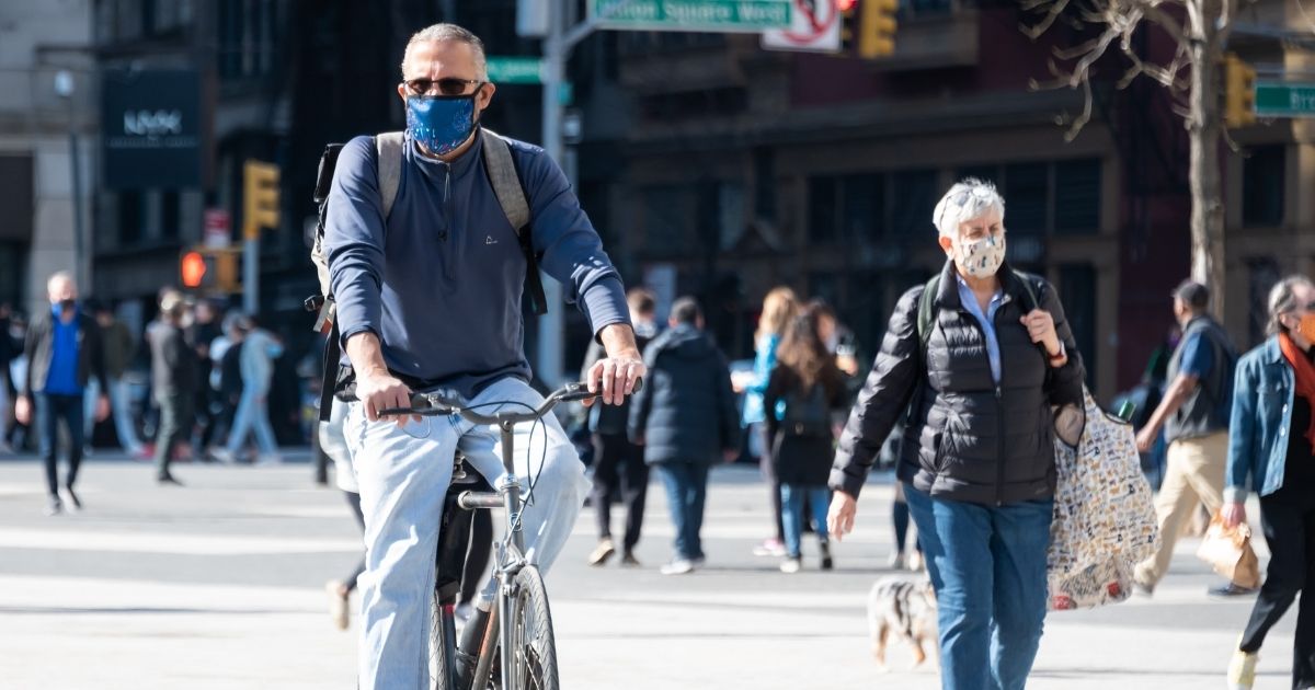 A person wearing a mask rides a bicycle in Union Square on Sunday in New York City.