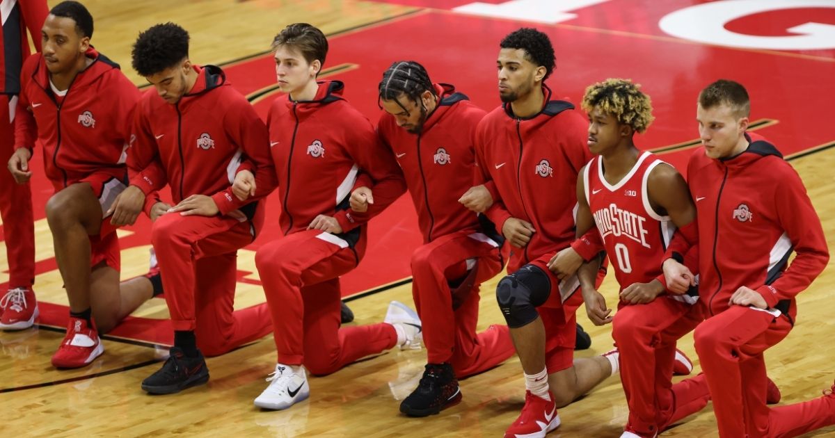 Ohio State Buckeyes players kneel during the national anthem before the start of a college basketball game against the Rutgers Scarlet Knights at Rutgers Athletic Center on Jan. 9, 2021, in Piscataway, New Jersey.