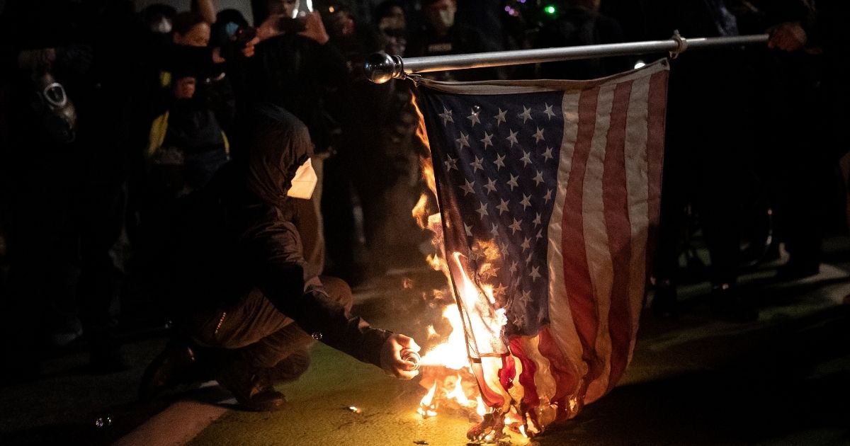 Black protesters burn an American flag on Nov. 4, 2020, in Portland, Oregon.