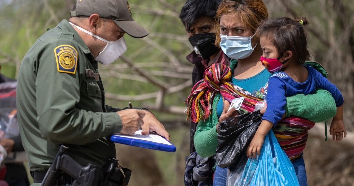 A U.S. Border Patrol agent questions asylum seekers after they crossed the Rio Grande into Hidalgo, Texas, on Thursday.