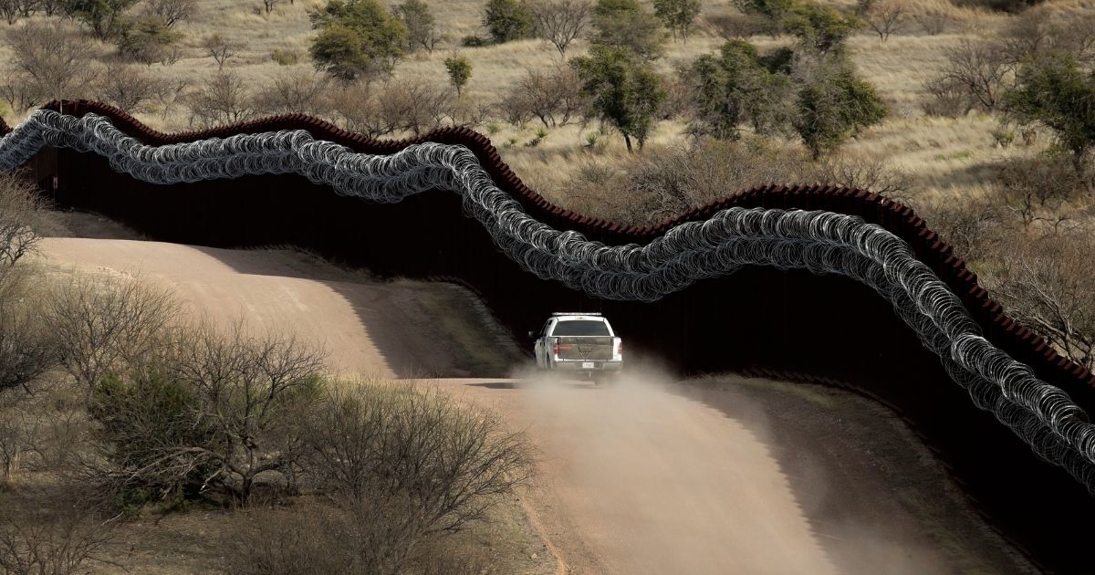 A Customs and Border Patrol agent patrols the U.S. side of a razor-wire-covered border wall along the Mexico east of Nogales, Arizona, on March 2, 2019.