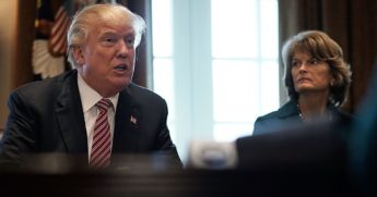 Then-President Donald Trump speaks as Alaska Sen. Lisa Murkowski looks on during a meeting with congressional members at the Cabinet Room of the White House on Feb. 14, 2018.