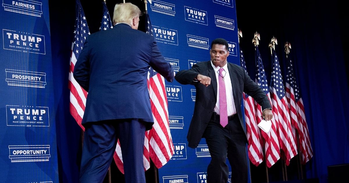 Former President Donald Trump is greeted by NFL hall of fame member Herschel Walker during an event for black supporters at the Cobb Galleria Centre on Sept. 25, 2020, in Atlanta.
