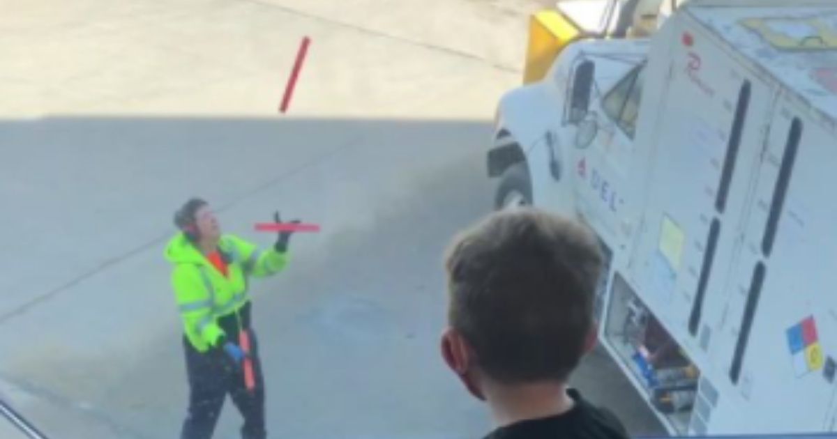 An employee at Sioux Falls Regional Airport in South Dakota juggles traffic safety batons while passengers wait for their flight.