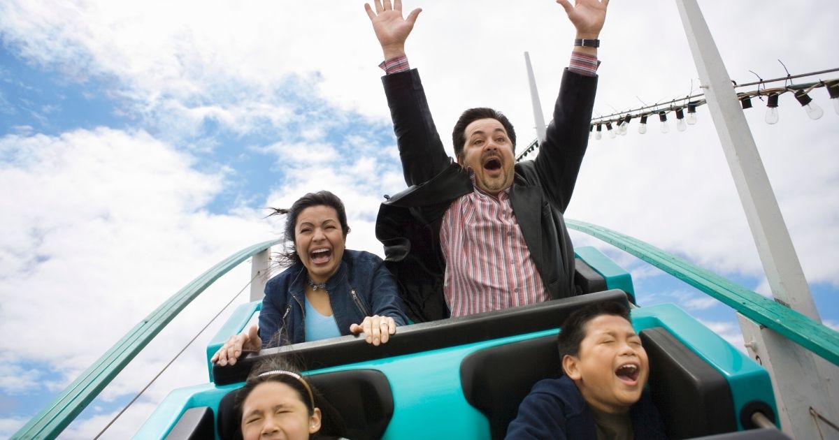 A family rides a roller coaster in this stock photo. The California Attractions and Parks Association, in its reopening plan, maintains that 'face covering usage and/or modifications to seat loading patterns will be required on amusement park rides to mitigate the effects of shouting' in an effort to prevent the spread of COVID-19.