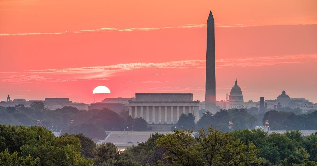 The sun rises over Washington, D.C., in the stock image above.