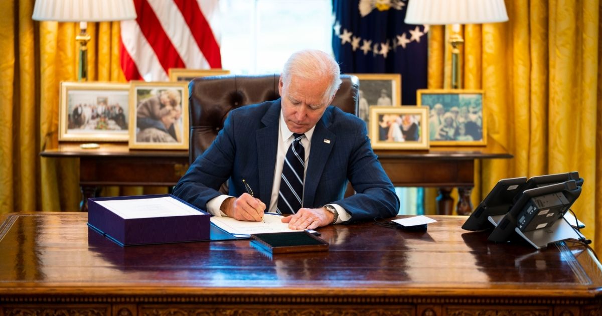 President Joe Biden signs a bill in the Oval Office of the White House on March 11, 2021, in Washington, D.C.