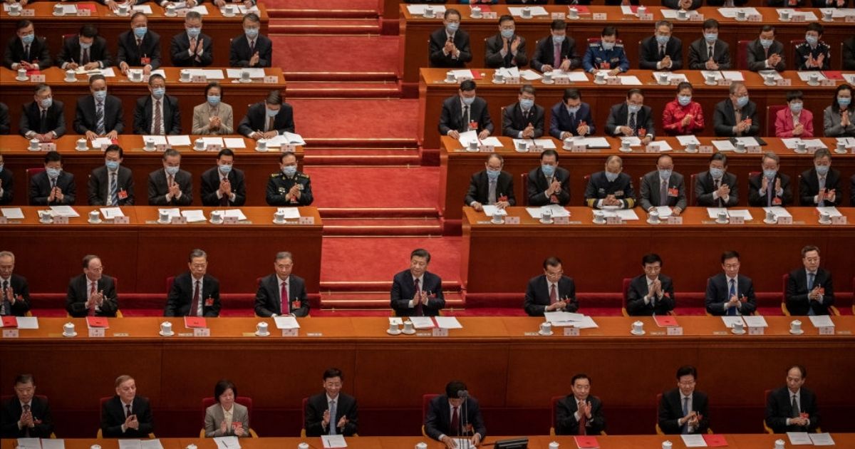 Chinese President Xi Jinping, center, and lawmakers applaud during the closing session of the National People's Congress at the Great Hall of the People on March 11, 2021, in Beijing, China.
