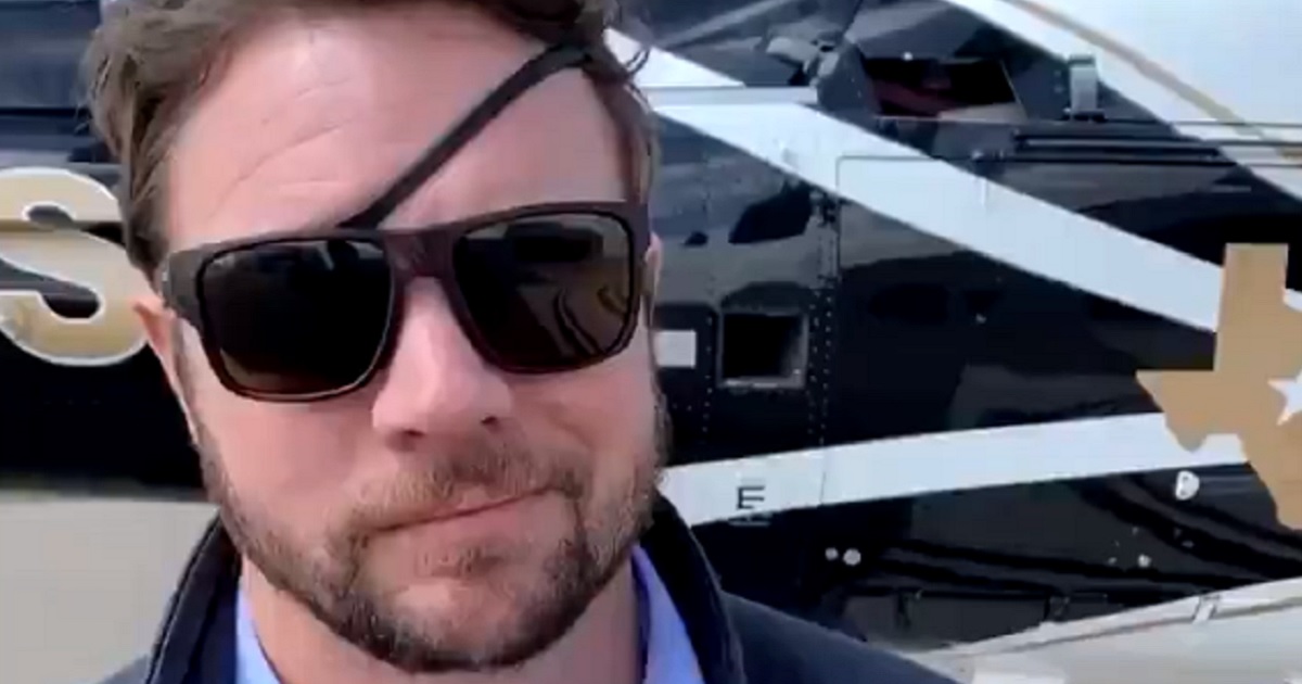 U.S. Rep. Dan Crenshaw stands in front of a helicopter during a tour of the U.S. southern border on Saturday.