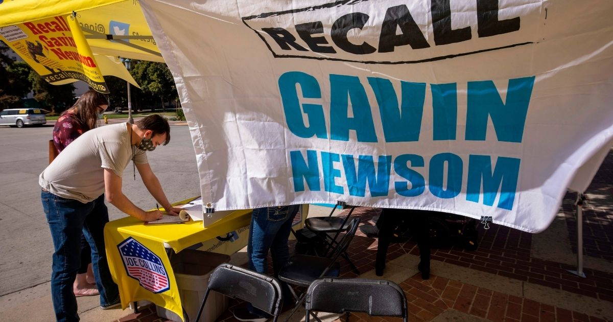 A man signs a petition to recall California Gov. Gavin Newsom near Pasadena City Hall in Pasadena, California, on Feb. 28, 2021.