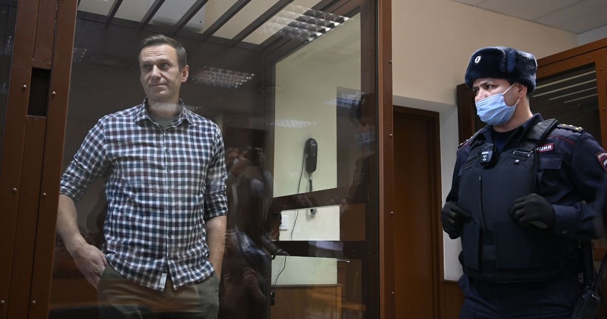 Russian opposition leader Alexei Navalny stands inside a glass cell during a court hearing at the district court in Moscow on Feb. 20, 2021.