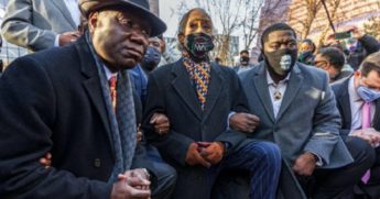 MSNBC personality Al Sharpton, flanked by attorney Benjamin Crump, left, and Pilonise Floyd, the brother of George Floyd, right, kneels outside the Minneapolis courthouse on Monday.