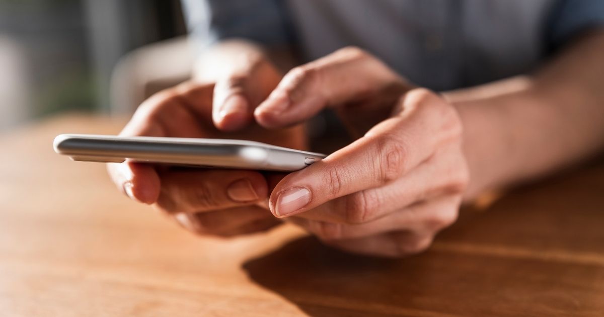 A woman holds a cellphone in this stock image.