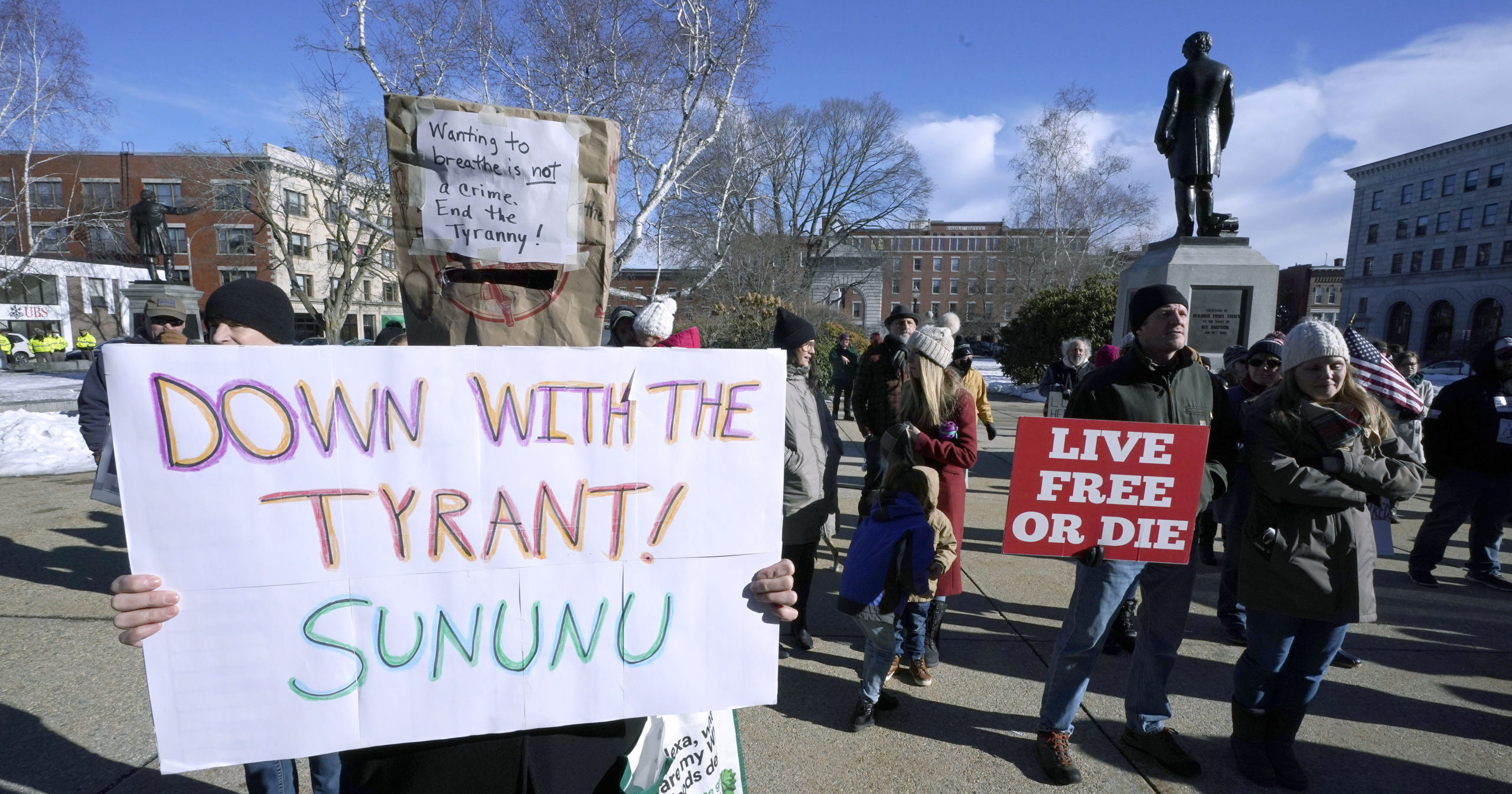 People protest outside the statehouse in Concord, New Hampshire, as Gov. Chris Sununu is inaugurated for his third term as governor on Jan. 7, 2021.