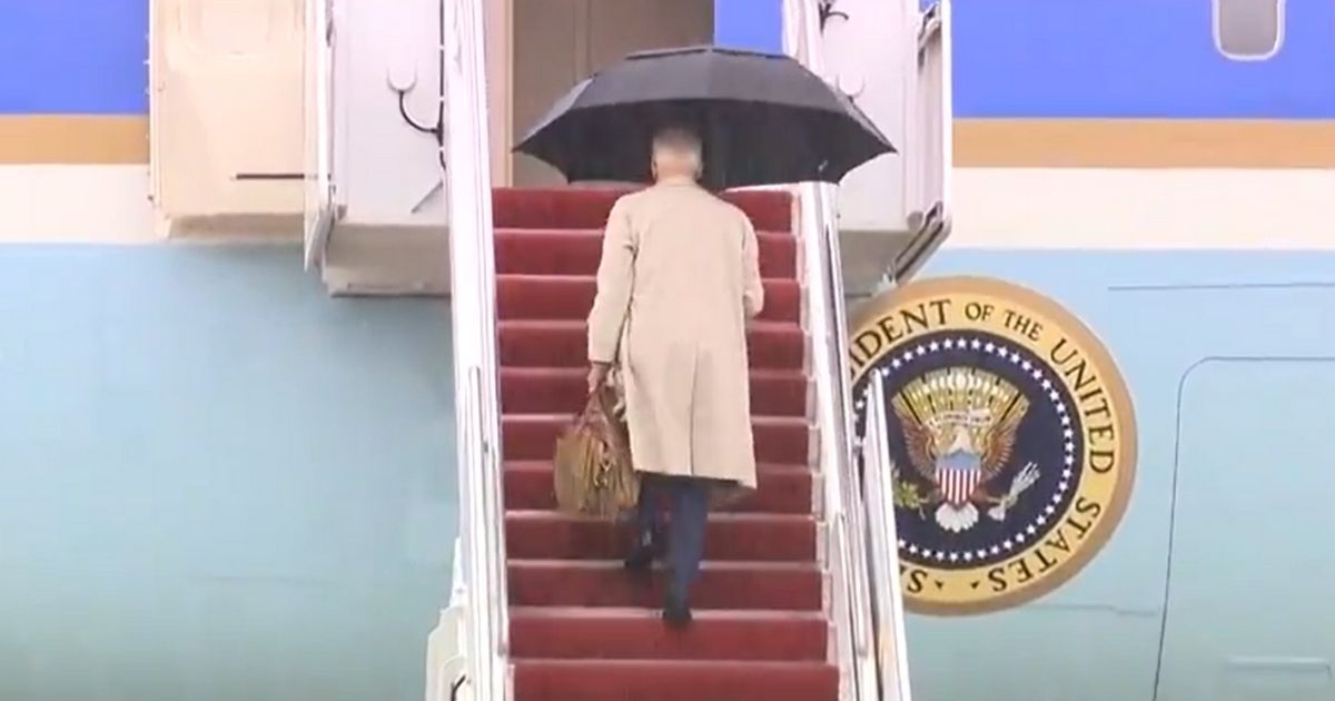 President Joe Biden walks up the steps of Air Force One.