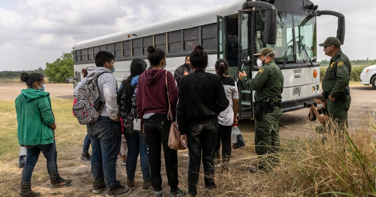 Central American immigrants wait to be transported to a processing center by U.S. Border Patrol agents near the border with Mexico on April 11 in La Joya, Texas.