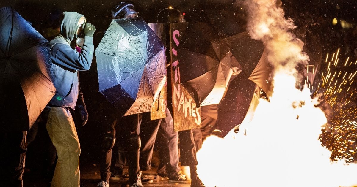 Demonstrators react when a crowd-dispersal canister goes off outside the Brooklyn Center Police Department in Brooklyn Center, Minnesota, on Tuesday.