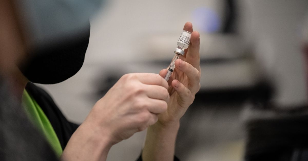 A pharmacy technician fills syringes of COVID-19 vaccines in the gymnasium at Whitney M. Young Elementary School on April 2 in Louisville, Kentucky.