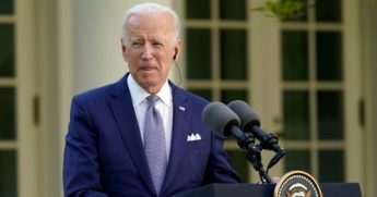 President Joe Biden listens as Japanese Prime Minister Yoshihide Suga speaks at a news conference in the Rose Garden of the White House on Friday in Washington.