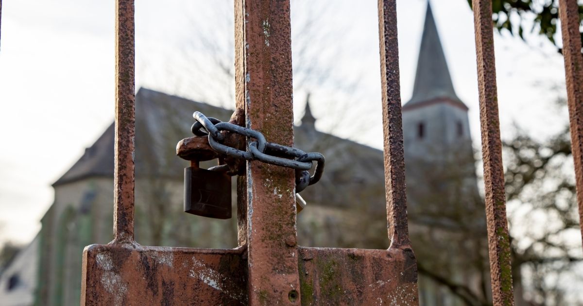This stock photo shows an iron gate with a chained lock on it in front of a church. Canadian authorities arrived at GraceLife Church near Edmonton, Alberta, on Wednesday to "physically close" the church after it repeatedly violated COVID-19 restrictions.