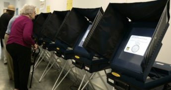 Local residents stand near voting booths as they prepare to cast their vote at City Hall as residents begin early voting in a New Orleans election on April 11, 2006, in New Orleans.