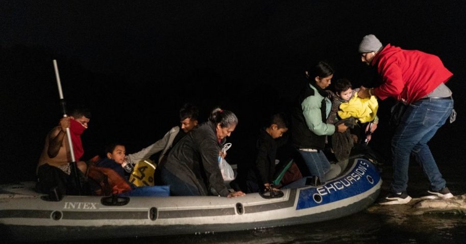 Asylum-seeking migrants' families disembark from an inflatable raft after crossing the Rio Grande river into the United States from Mexico on Friday in Roma, Texas.