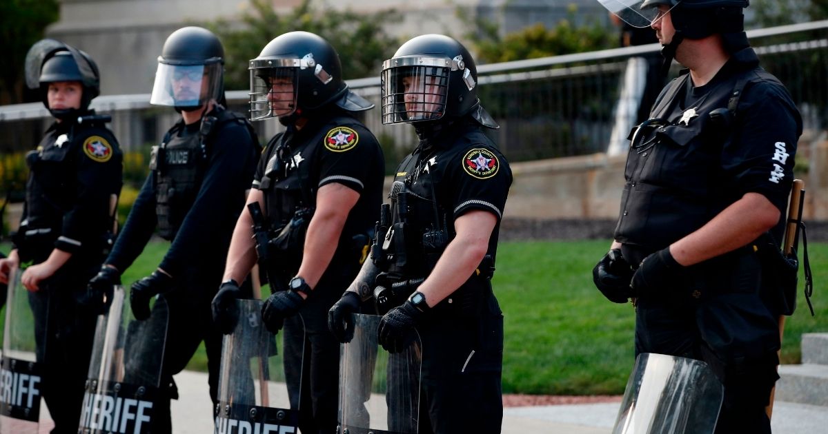 Kenosha County Sherriff's Department officers stand in line in front of the County Court House as people demonstrate against the shooting of Jacob Blake in Kenosha, Wisconsin, on Aug. 24, 2020.