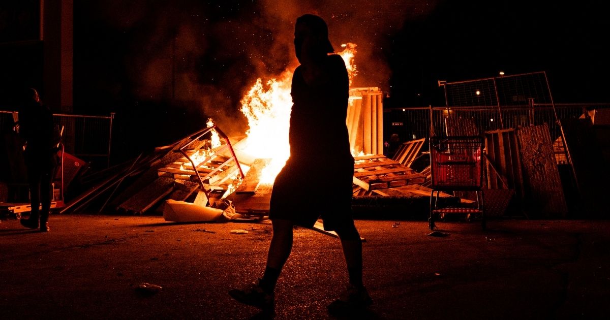 A fire rages in the street just north of the 3rd Police Precinct on May 27, 2020, in Minneapolis.