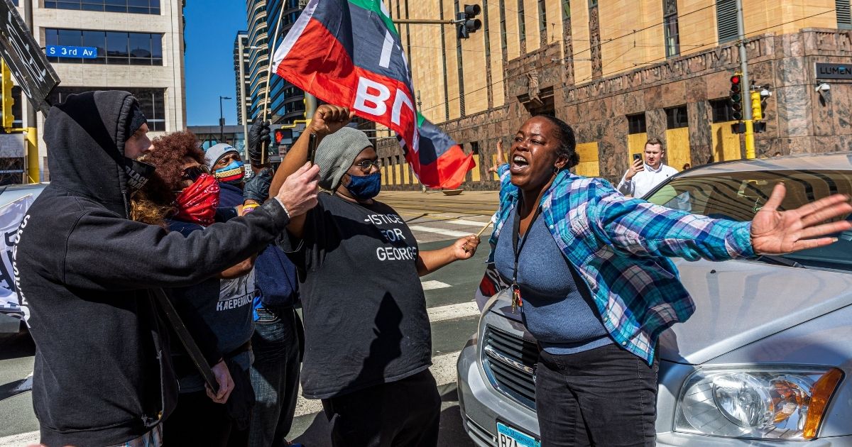 A woman argues with protesters for blocking a street outside the Hennepin County Government Center during the opening statement of former Minneapolis police officer Derek Chauvin on March 29, 2021, in Minneapolis.