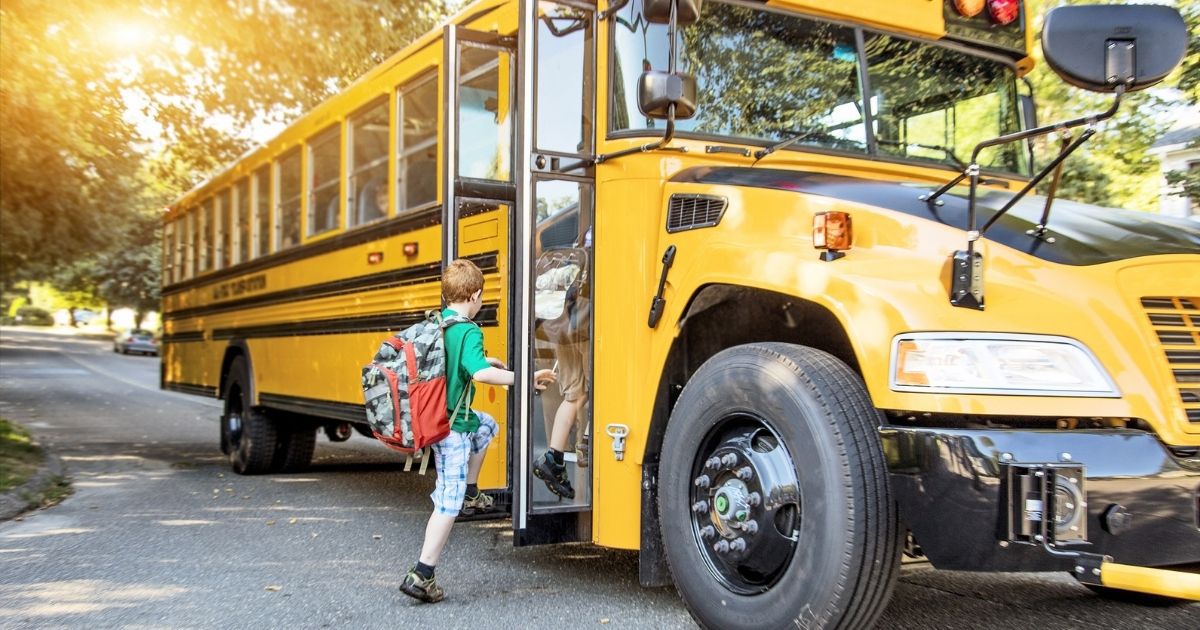 Kids get on a school bus in this stock image.