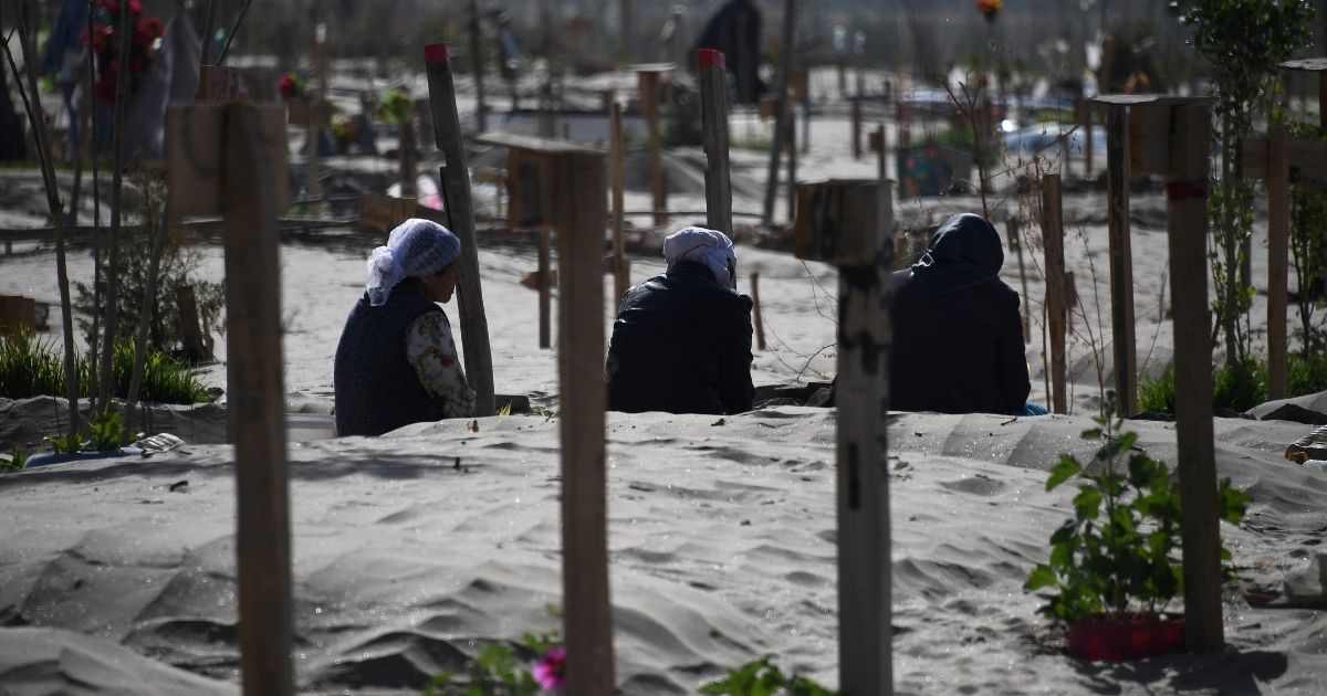 This photo taken on May 31, 2019, shows Uighur women praying in a graveyard on the outskirts of Hotan in China's northwest Xinjiang region.