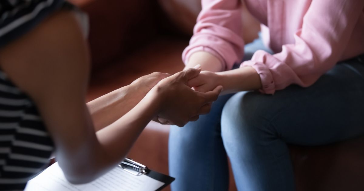 A woman receives counseling from another woman with a clipboard.