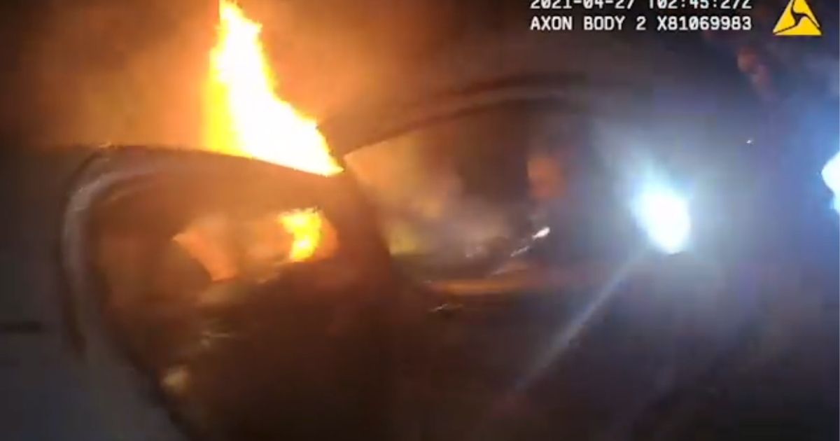A shot from a Savannah officer's bodycam showing the burning car that police rescued a teenager from.