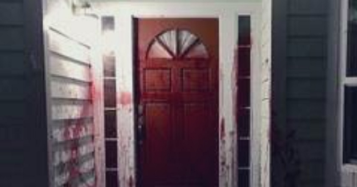 A front door with walls splattered with blood.