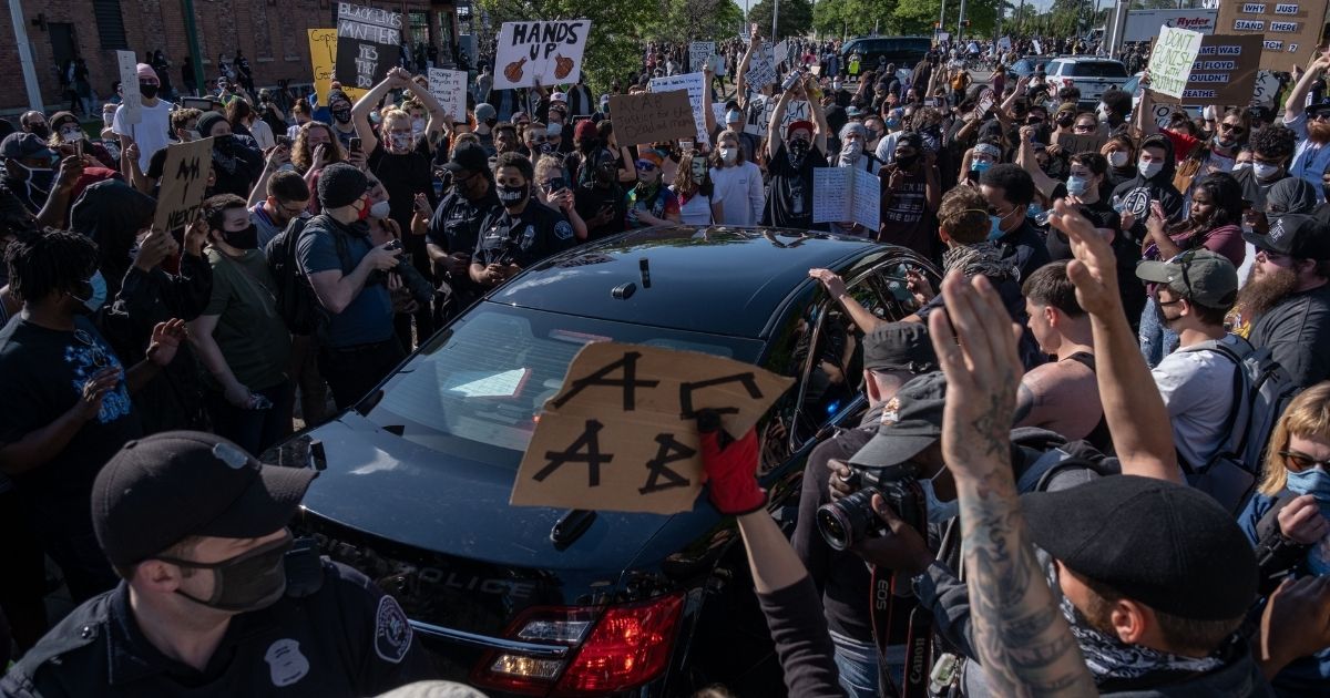 Protesters surround a Detroit police car after a demonstrator was arrested during a protest in Detroit on May 29, 2020.