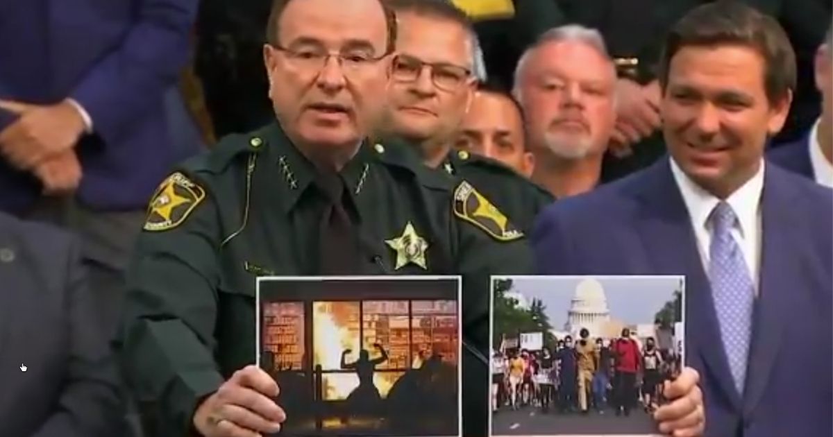 Polk County, Florida, Sheriff Grady Judd shows photographs of a protest and a riot during a news conference on Monday.