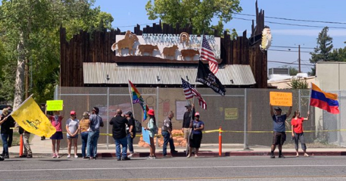 Supporters of the Tinhorn Flats Bar & Grill in Burbank, California, gather outside the restaurant after the city put up a fence around it.