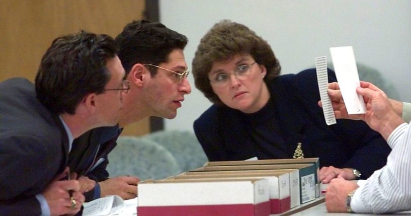 Democratic observer Joe Kaplan, left, Republican observer Jack Young, center, and court clerk Glenda Spears, right, examine ballots being held by judges during the counting of the 9000 under ballots at a public library on Dec. 9, 2000, in Tallahassee, Florida.