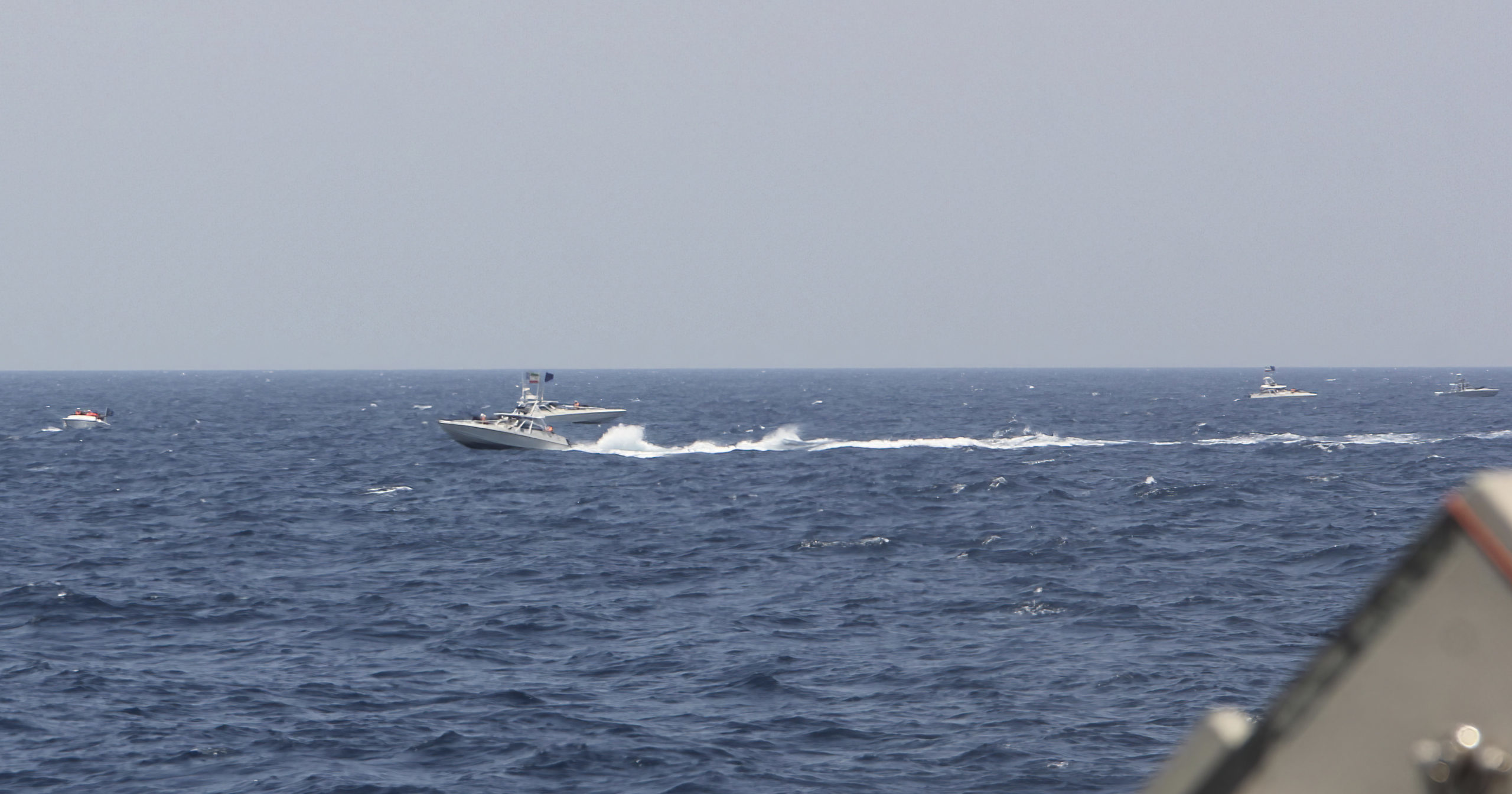 An Iranian Islamic Revolutionary Guard Corps Navy attack craft speeds near U.S. naval vessels transiting the Strait of Hormuz on Monday.
