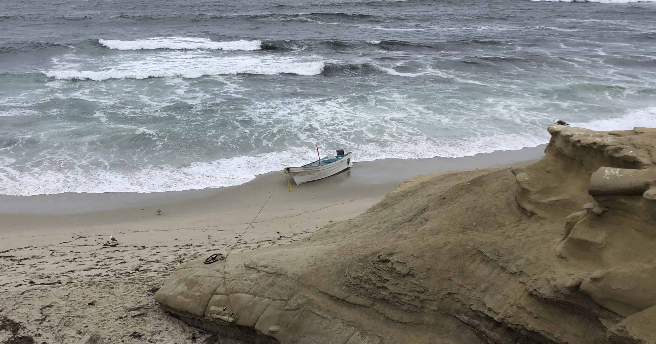 A small boat used during a suspected human smuggling operation sits on a San Diego beach on Thursday.