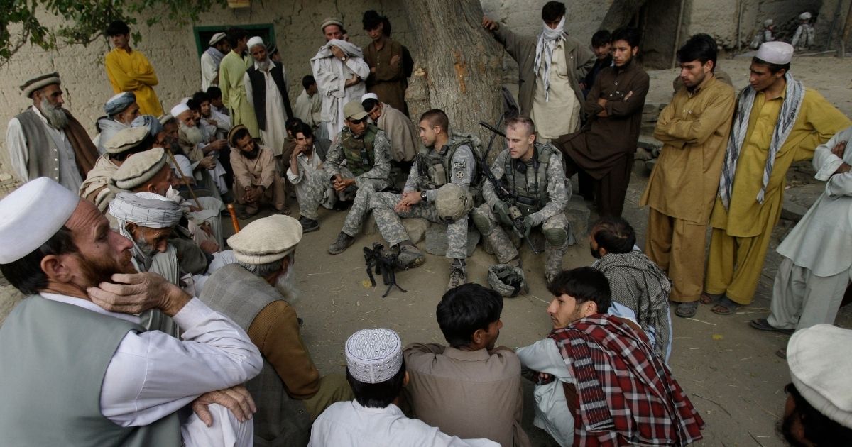 In this Nov. 3, 2009, file photo, Lt. Thomas Goodman, center, of the 2nd Battalion, 12th Infantry Regiment, 4th Brigade Combat Team, 4th Infantry Division meets with villagers in Qatar Kala in the Pech Valley of Afghanistan's Kunar province with his interpreter Ayazudin Hilal, center left with hat. Hilil served as an interpreter alongside U.S. soldiers on hundreds of patrols and dozens of firefights in eastern Afghanistan, earning a glowing letter of recommendation from an American platoon commander and a medal of commendation.