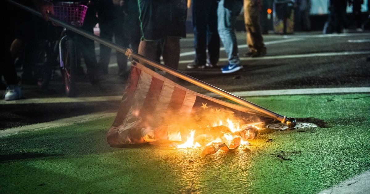 Protesters burn a U.S. flag in Portland, Oregon, on Nov. 4, 2020.